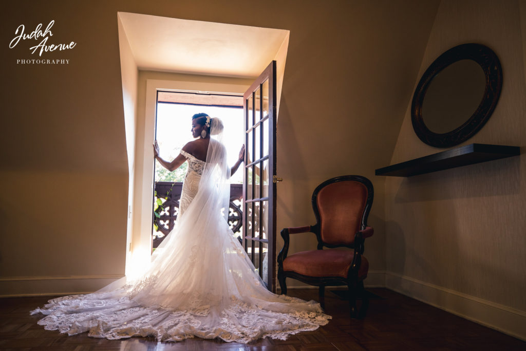 Black bride in dress overlooking window